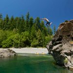 man jumping into Chetco River