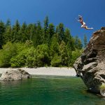 woman jumping into Chetco River