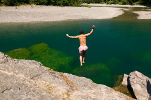 man jumping into Chetco River